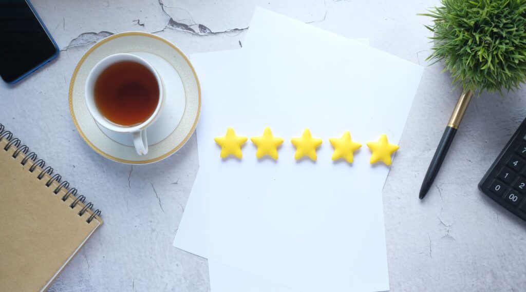 Customer review concept with Rating golden stars on table