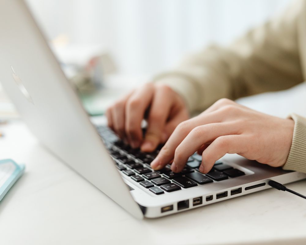 A Person Typing on a Laptop